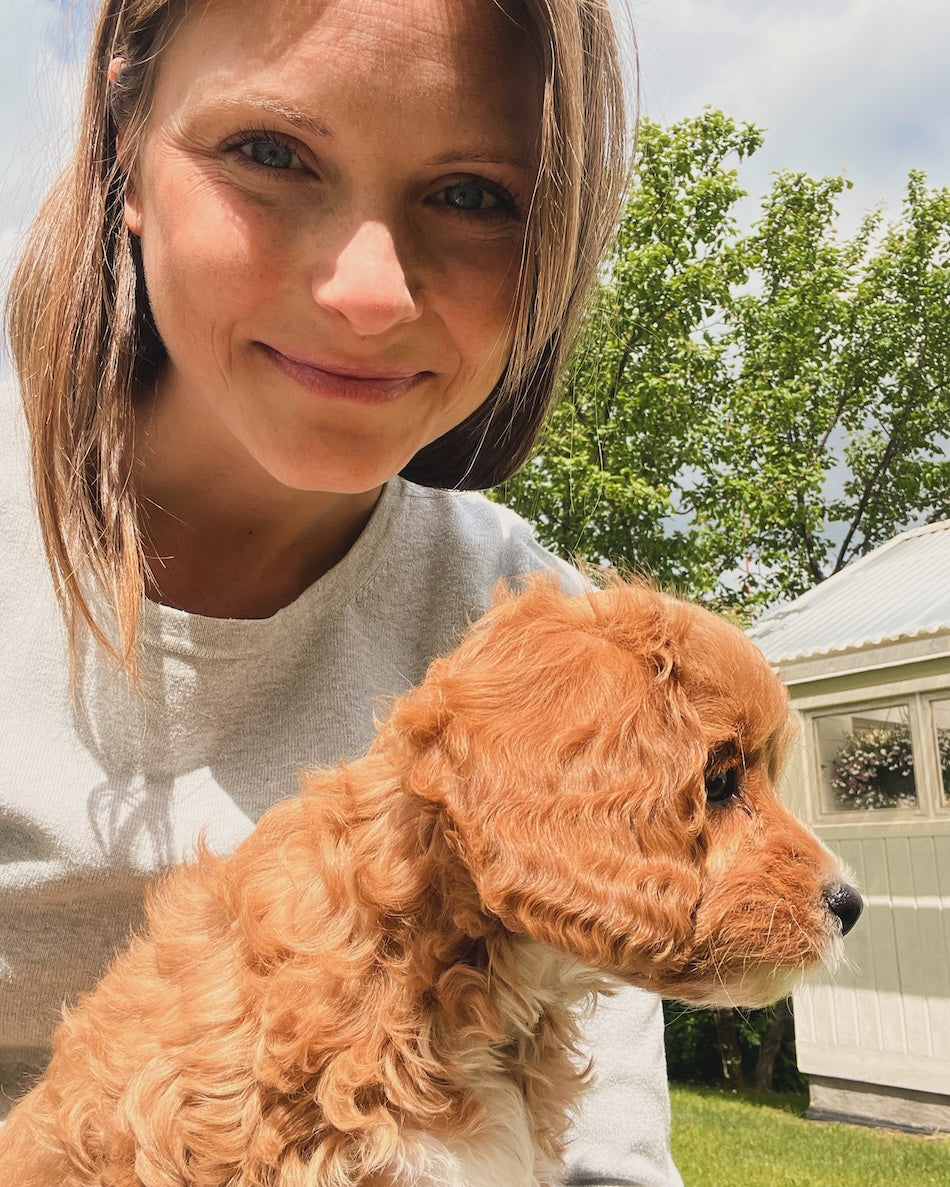 kvinna med liten aprikosfärgad hund